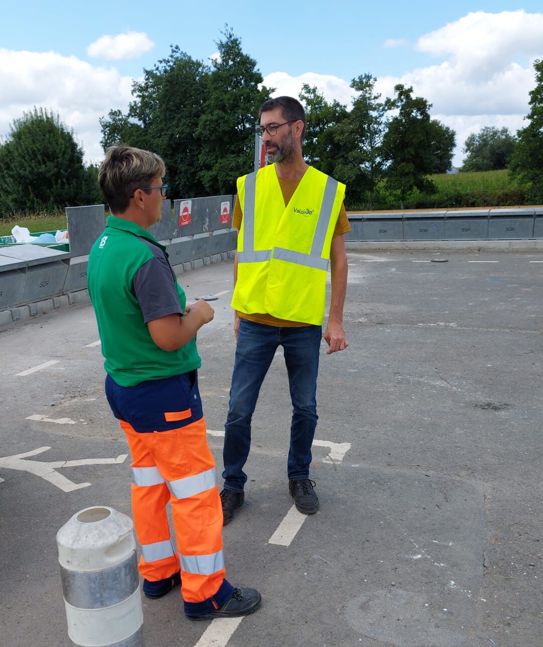 Yann en tournée sur les déchèteries, porte un gilet jaune. Il discute avec une agente d'accueil de la déchèterie de Saint Laurent des Autels.