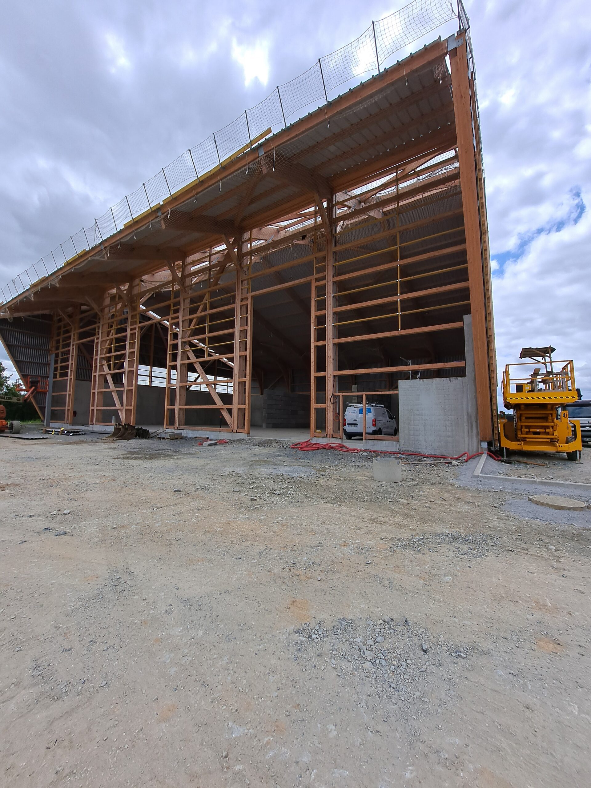 Couverture support des panneaux solaires en cours de pose. dernière façade à barder sur le bâtiment.